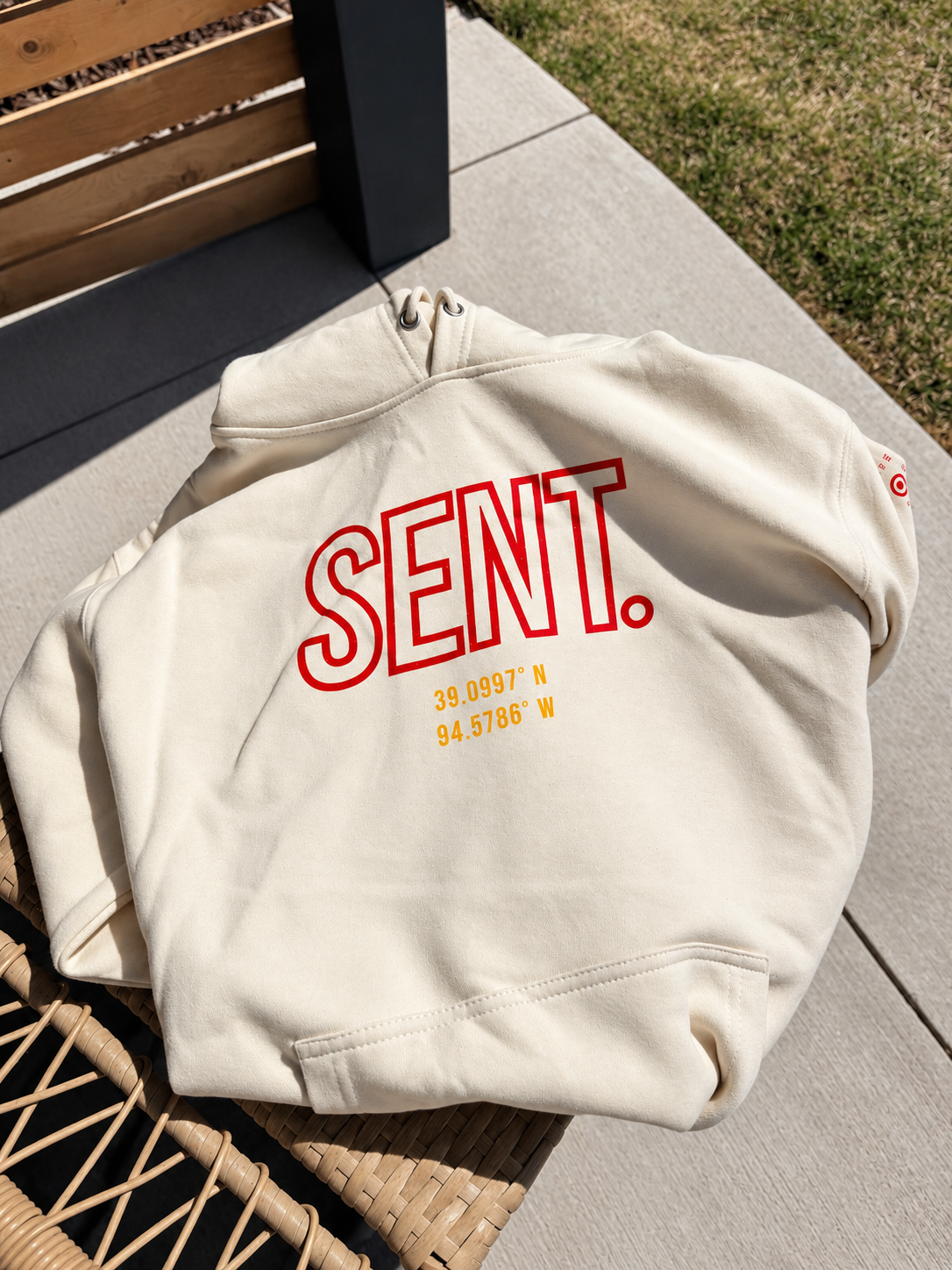 Bone KC SENT hoodie laid outdoors in sunlight