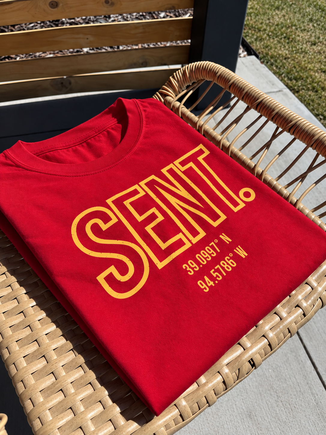 Red KC SENT garment laid outdoors in sunlight