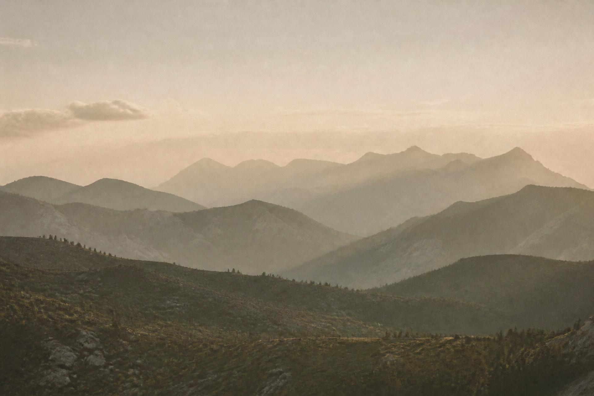 Layered mountain ridges fading into morning haze